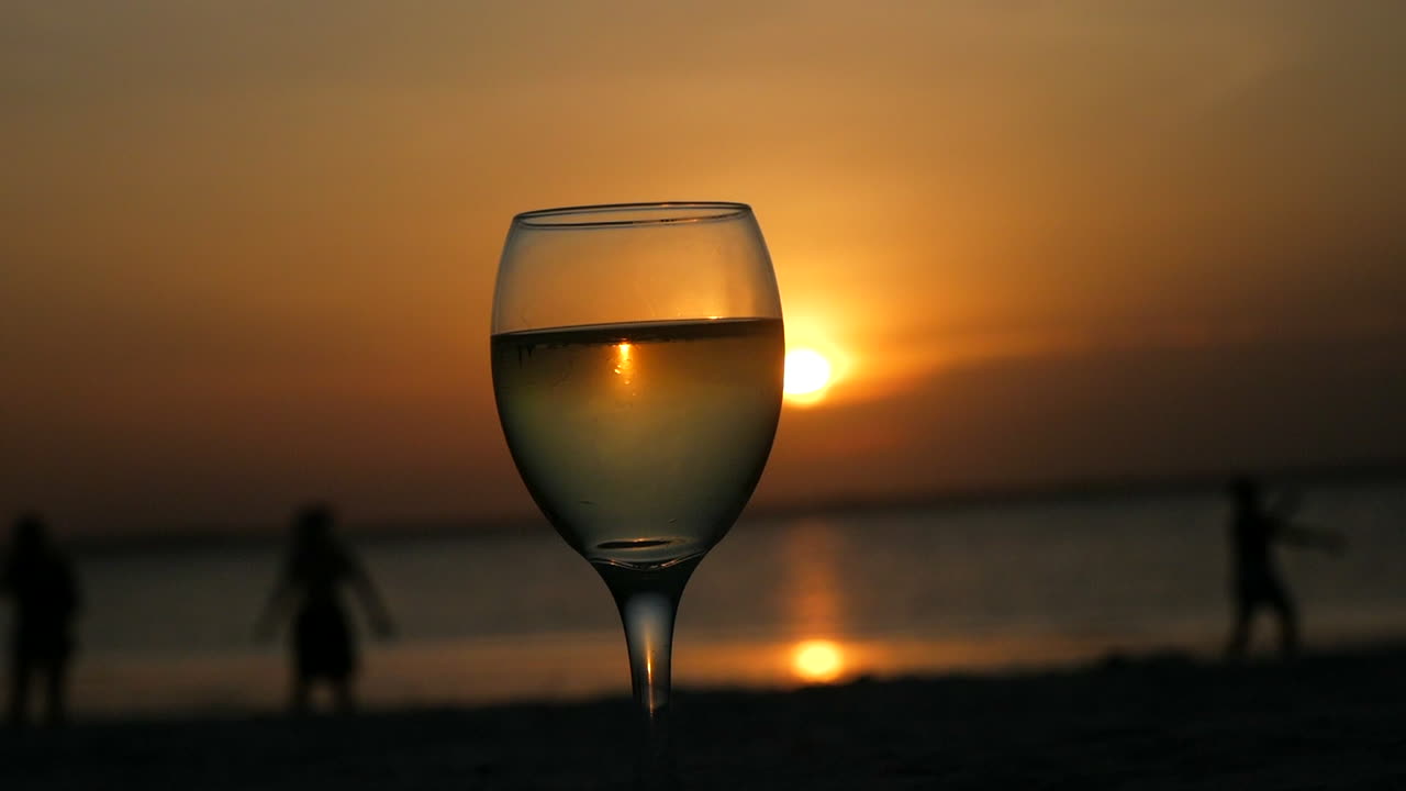 Bebendo uma taça de vinho no Oceano Índico com um lindo pôr do sol
