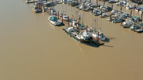 aerial orbital shot of boats and ships docked in brown and murky waters