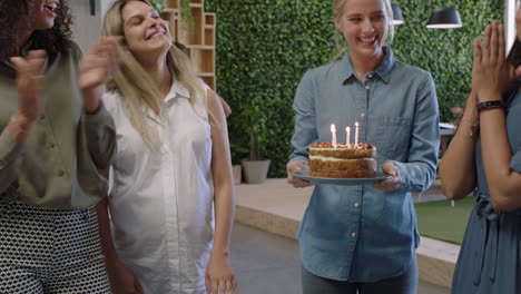 Gente-De-Negocios-Feliz-Celebrando-La-Fiesta-De-Cumpleaños-Mujer-Jefa-Soplando-Velas-Disfrutando-De-La-Fiesta-En-El-Lugar-De-Trabajo-De-Oficina