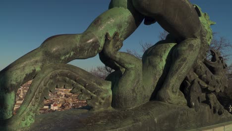 statue of a hungarian warrior fighting a three-headed dragon on top of gellert hill, budapest, hungary - tilt up shot