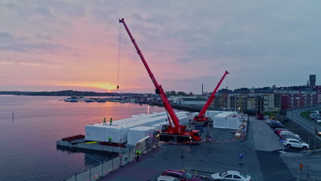 drone shot worker transporting container house at dock of slottsholen during sunrise in the morning