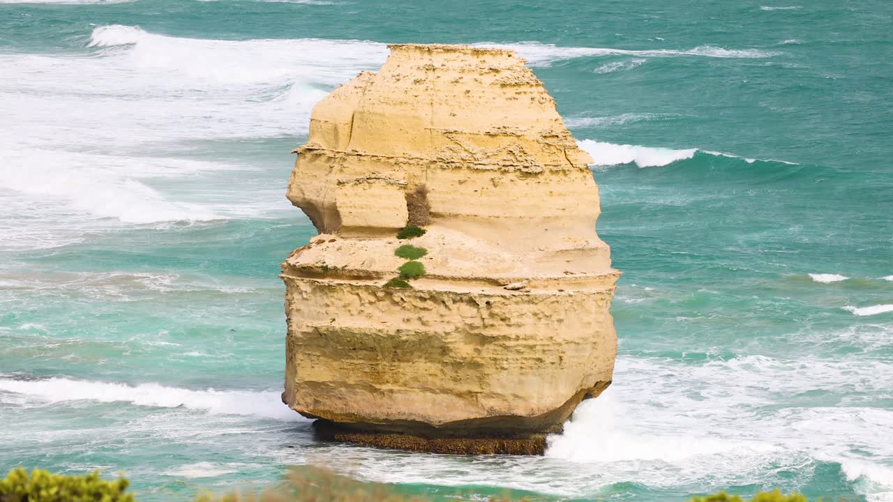 A serene view of the Twelve Apostles rock formation against turquoise ocean waves under bright daylight