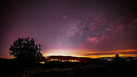 el lapso de tiempo revela un cielo nocturno púrpura adornado con innumerables estrellas en movimiento, luces de aviones y siluetas de árboles en primer plano