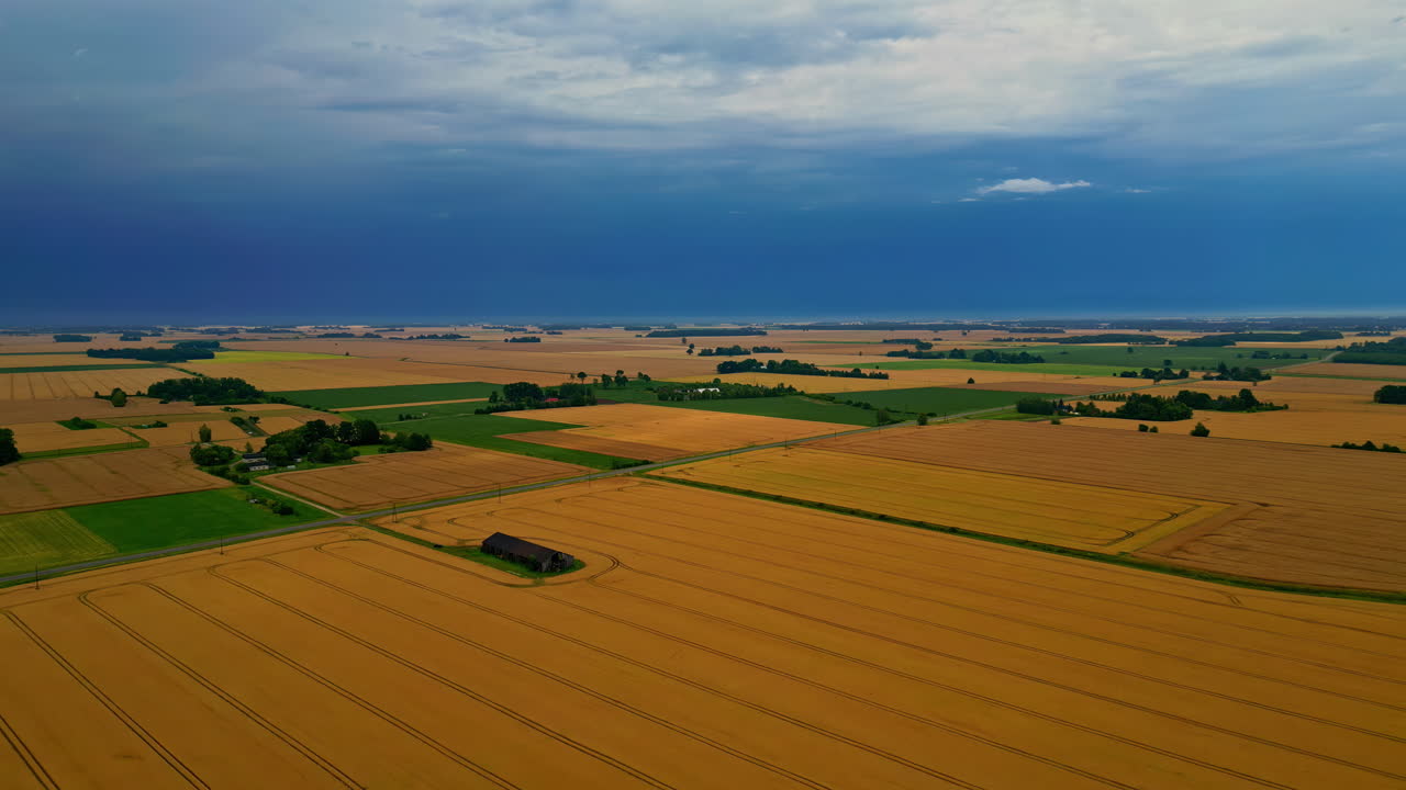 Aerial view of dramatic storm clouds above farmlands and countryside fields