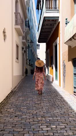 woman walking through a charming cobblestone street in san juan, puerto rico