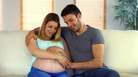 Pareja-Feliz-Sentada-En-El-Sofá