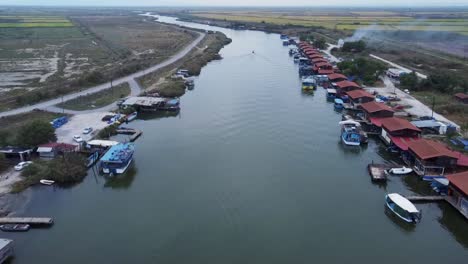 Aerial-flyover-Fisherman-Cabins-at-Axios-Delta-National-Park,-Greece-during-cloudy-day