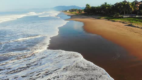 Reverse-revealing-a-picturesque-Mexican-coastline-of-golden-sand-and-breaking-waves