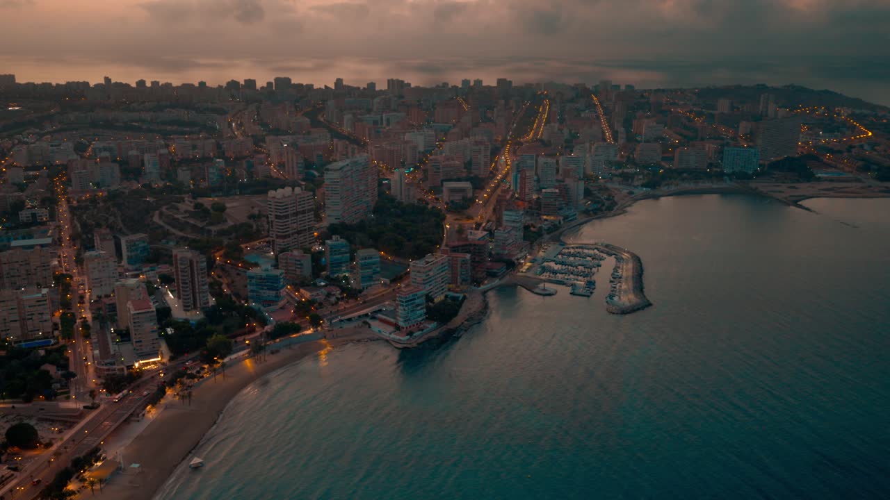 Seaside spanish city shot on night from above with buildings streets and cars