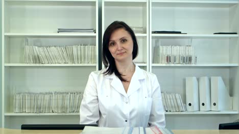 enfermera que clasifica los expedientes de los pacientes en la recepción del hospital