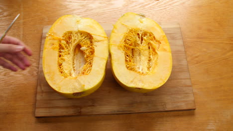 person prepares spahgetti squash