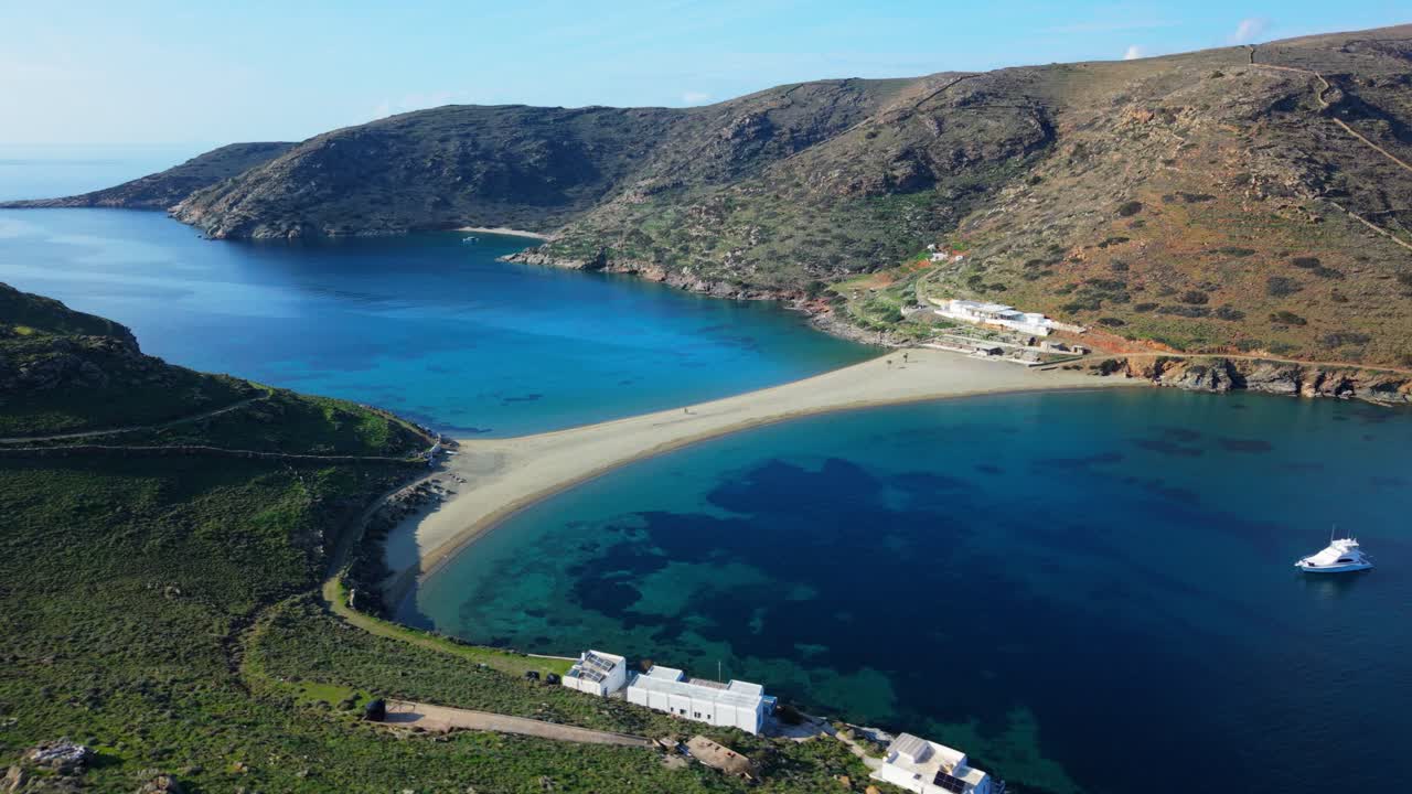 Aerial flyover of Kolona Beach with boats anchored in calm turquoise bays, steep cliffs surrounding, establishing