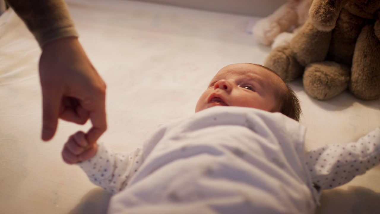 새로 태어난 아기 아들 과 함께 놀고 있는 어머니 가 잠자리에 들기 전 에 어린이 침대 에 누워 있다