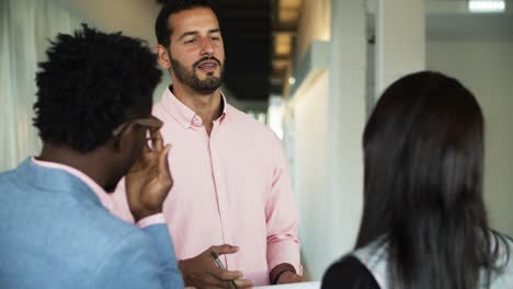 Smiling-young-people-communicating-in-corridor.