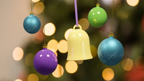 Animation-of-christmas-decorations-dangling-over-fairy-lights-in-background