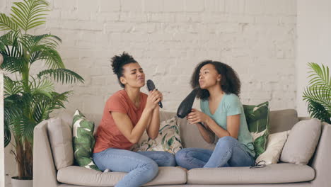two friends singing and having fun at home