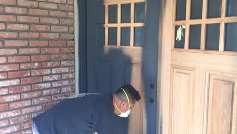 professional painter applying wood primer to wood doors with spray gun