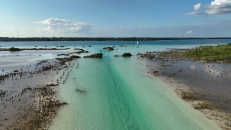 Vista-Aérea-Sobre-La-Laguna-Y-El-Canal-De-Los-Piratas-Hacia-La-Ciudad-De-Bacalar,-En-El-Soleado-México---Levantamiento,-Disparo-De-Drones