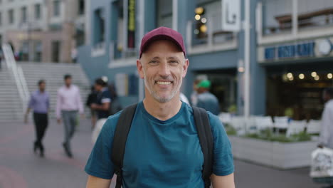 retrato de un turista caucásico maduro y atractivo con sombrero mirando a la cámara sonriendo el fondo de la ciudad