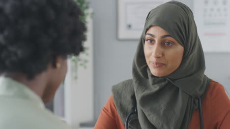 Close-Up-Of-Female-Doctor-Or-Consultant-Wearing-Headscarf-Having-Meeting-With-Female-Patient