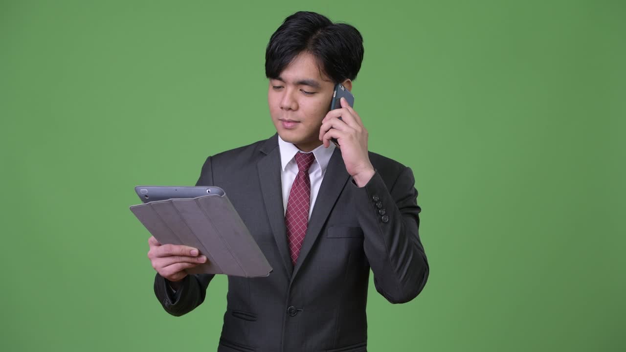 joven empresario asiático guapo usando una tableta digital