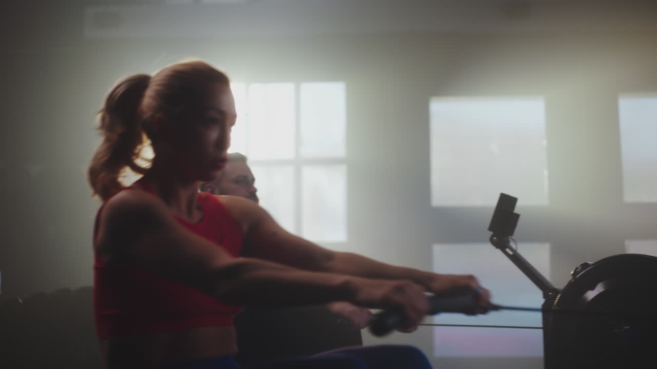 People working out on rowing machines in a gym
