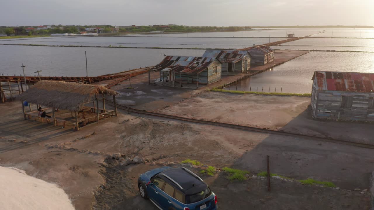vuelo hacia adelante en la mina de sal, vista del mini cooper azul y casas antiguas en una tarde soleada