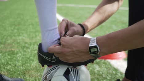 tying up some shoe laces for a young soccer player