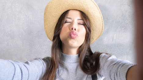 woman taking selfie in straw hat