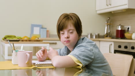 Young-girl-looking-at-camera,-showing-her-toung-and-doing-homework