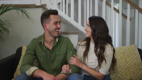 portrait of caucasian couple sitting on sofa and smiling