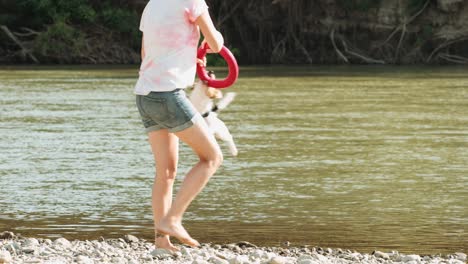 woman playing with dog near river