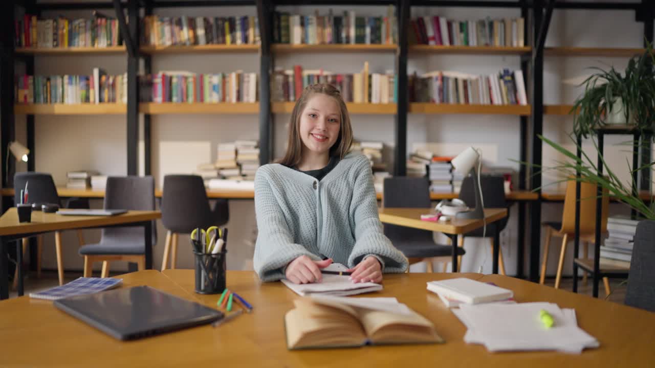 девочка-подросток учится в библиотеке