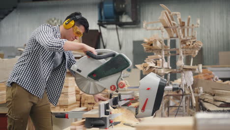 carpenter using circular saw in workshop