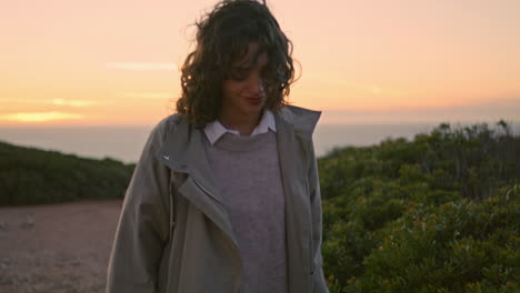 Travel-girl-walking-evening-hill-at-ocean-view.-Serene-woman-touching-bushes