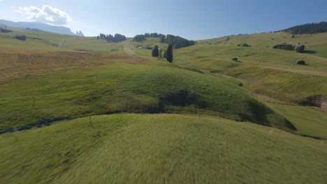 fpv drone aerial view speeding across italian dolomites lush countryside chalets passing farmland animals