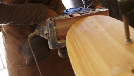 Surfboard-maker-using-polisher-machine-on-surfboard-4k