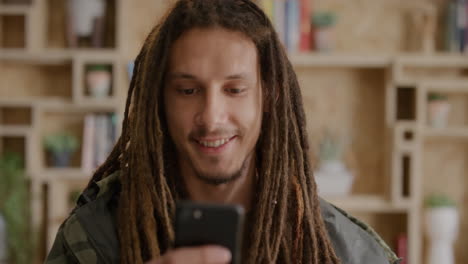 portrait of happy young mixed race man student using smartphone texting browsing online messages enjoying mobile communication relaxed guy with dreadlocks