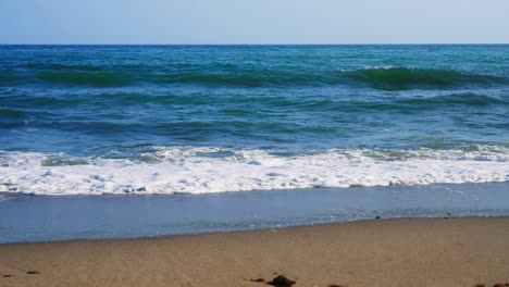 empty beach with calm waves crashing on the shore