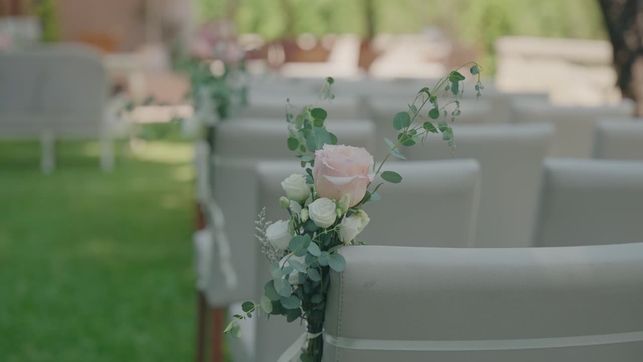정원 배경의 결혼식 통로 의자에 놓인 우아한 꽃 장식