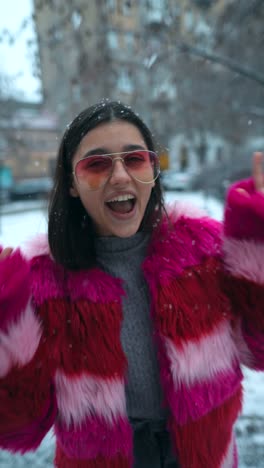 smiling woman in pink fur coat in the snow