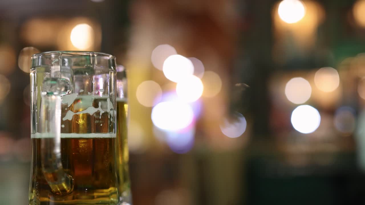 un vaso de cerveza se destaca contra un fondo nocturno borroso y colorido, capturando una atmósfera animada y vibrante