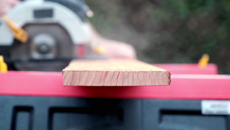 power tool in action, close up slow motion shot of electric round saw cutting through wooden plank