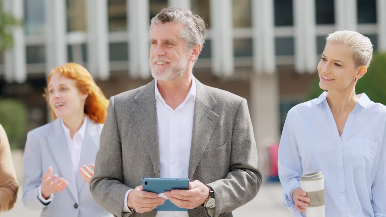 Diverse group of business professionals walking and talking outside an office building
