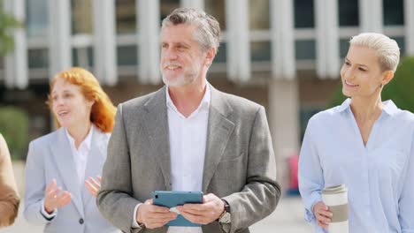 diverse group of business professionals walking and talking outside an office building