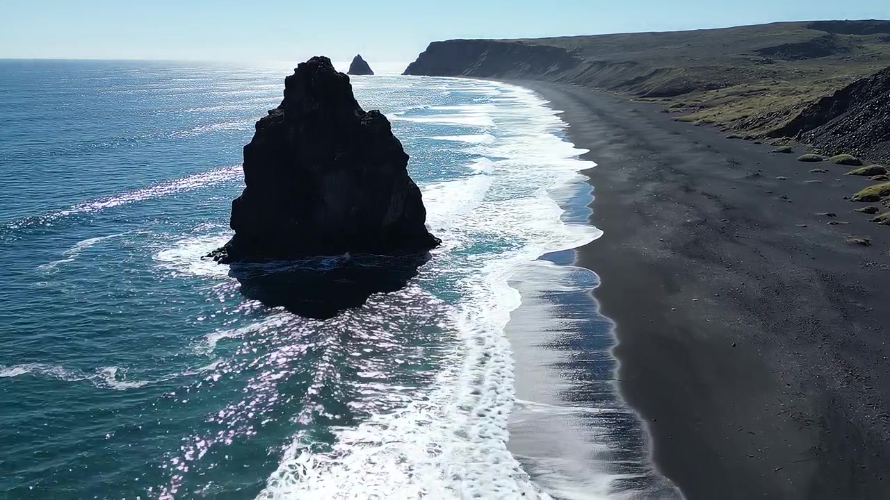 Flyfoto av dramatisk sjøstabel på vulkansk svart strand