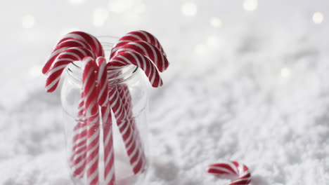 video of christmas candy canes in jar and copy space on snow background