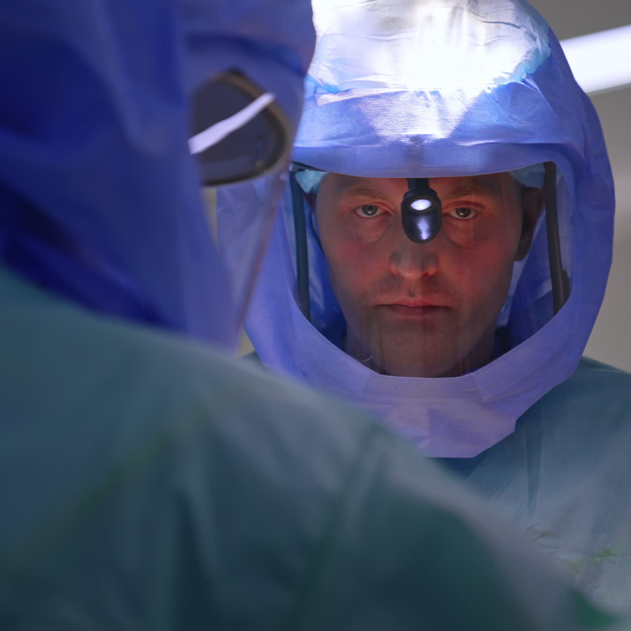 Medici uomini che indossano caschi protettivi nella sala operatoria. Medici che eseguono un'operazione