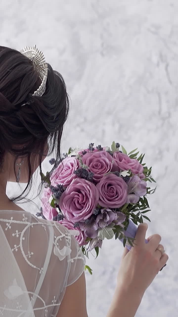 Sposa con un bellissimo bouquet di rose viola