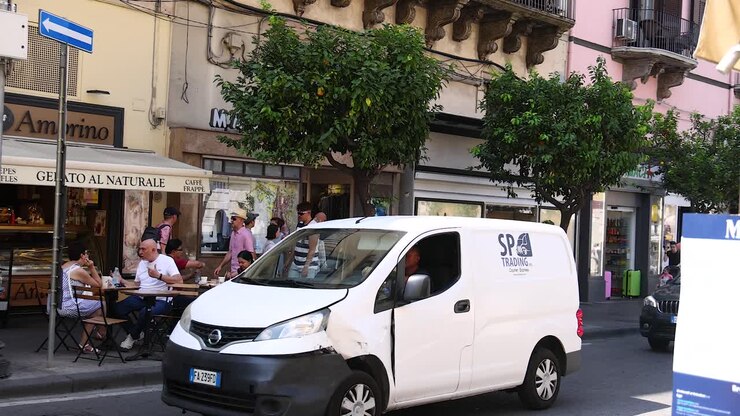 People dining outside, vehicles passing by